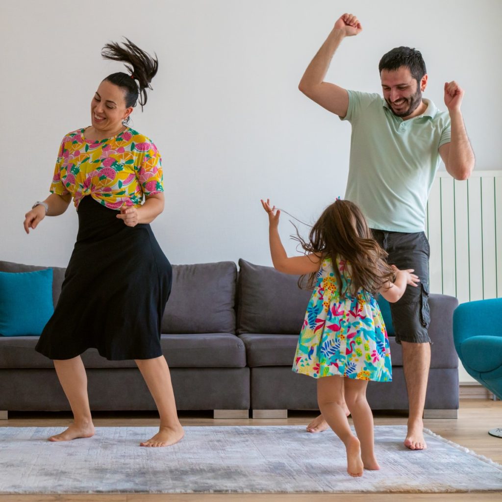 A family dances in their living room.