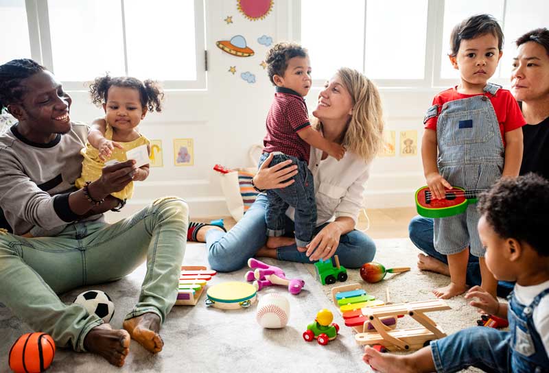 Parents of young toddlers gather together in a community play room.