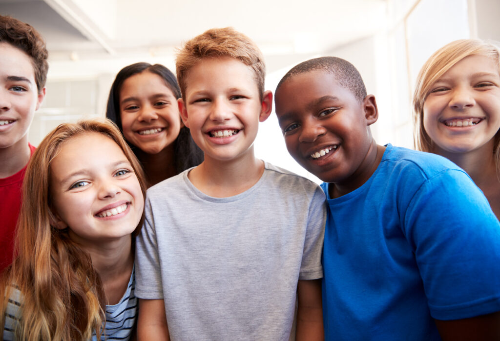 Portrait of smiling diverse group of students in elementary school classroom