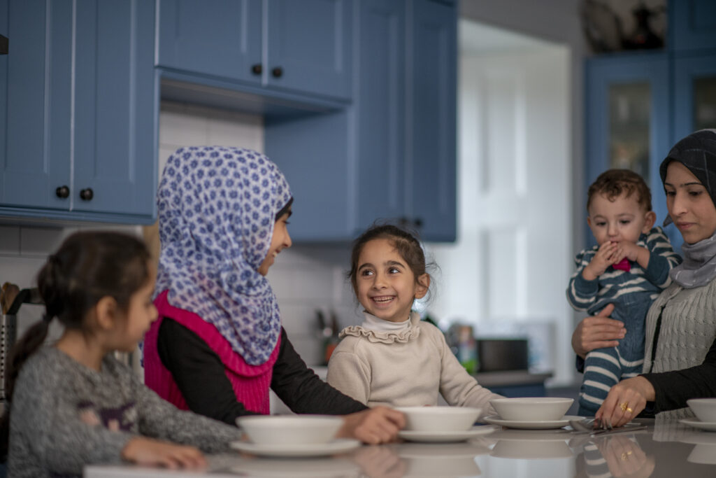 A Muslim family gathers around the dinner table to prepare for supper.